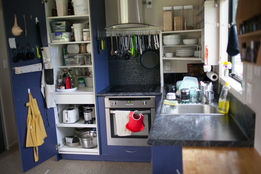Tiny Organized Kitchen with pantry door open