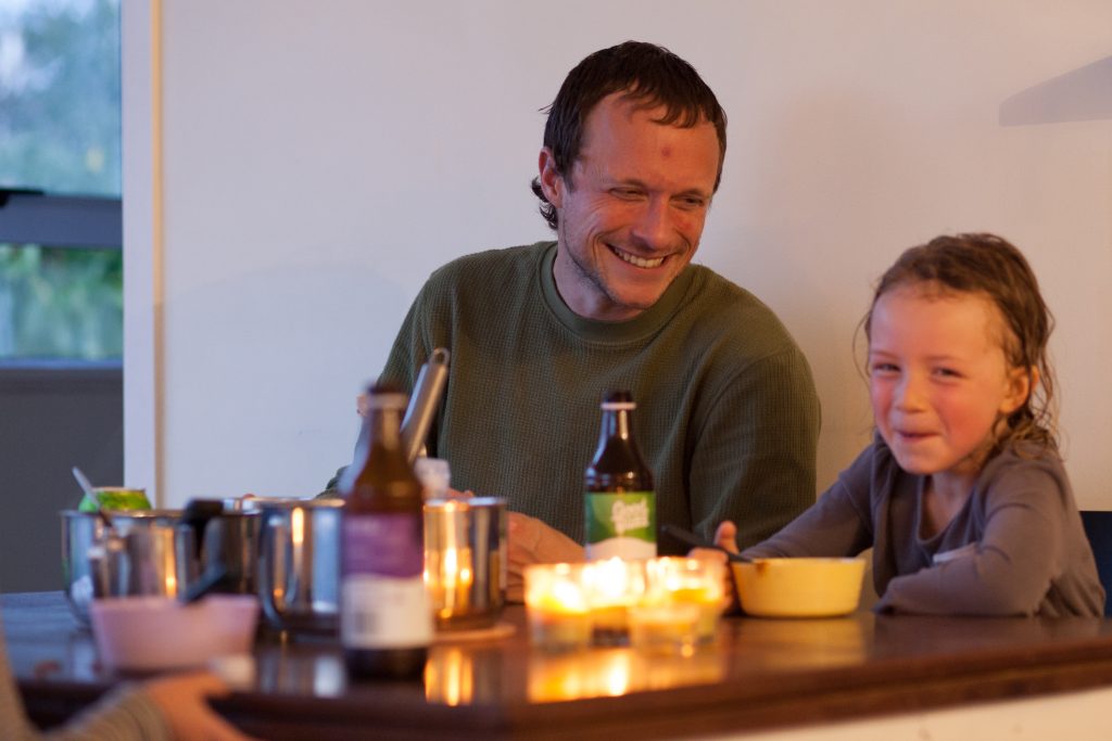Dad and daughter eating dinner with candlelight for restful sabbath