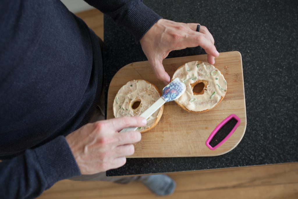 man spreading cashew cream on bagels for one month meal plan