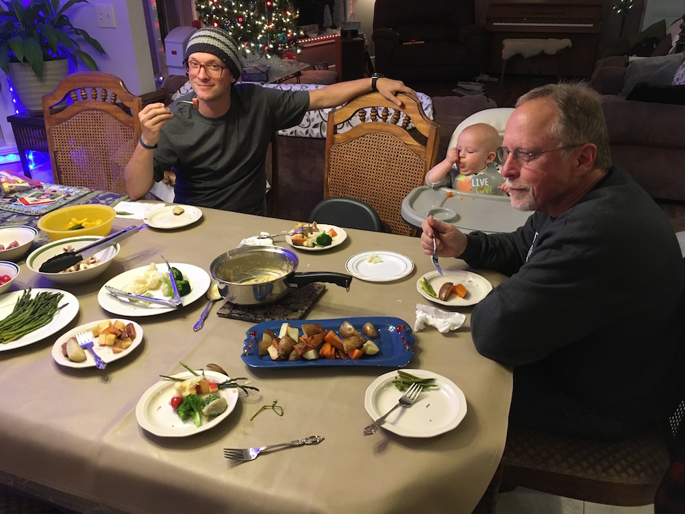 Dad, son, and Grandfather finishing Christmas Eve fondue dinner