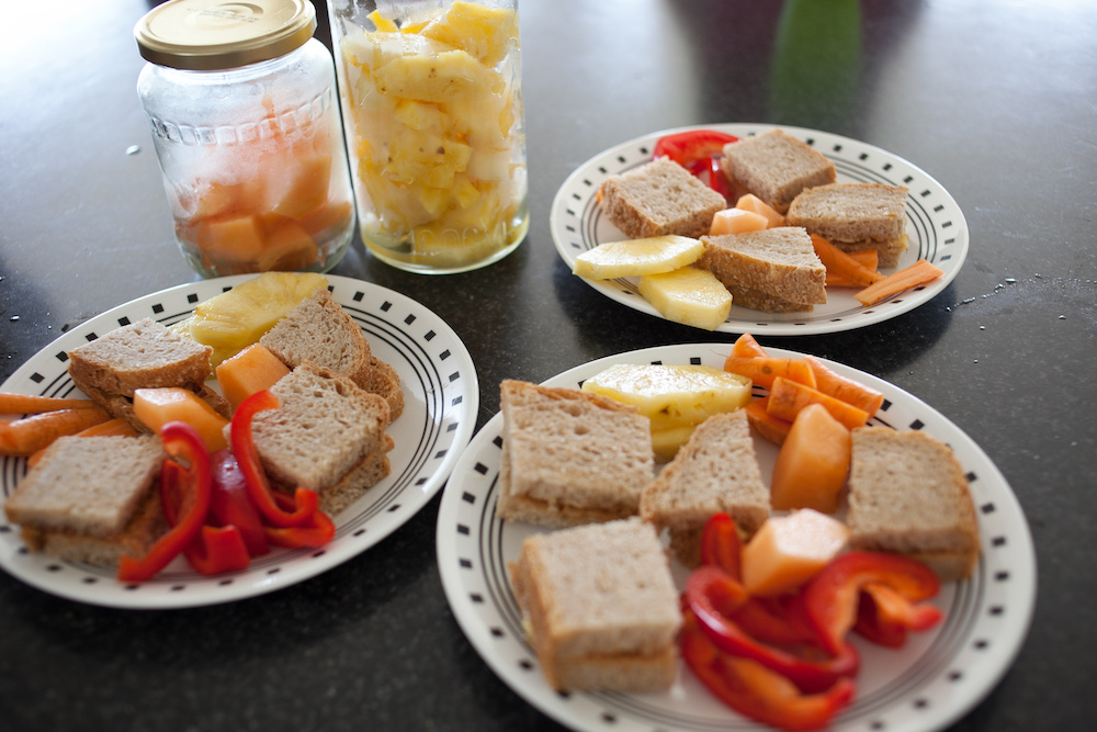 PBJ Sandwiches, fruit, and veggies on plate for kids lunches