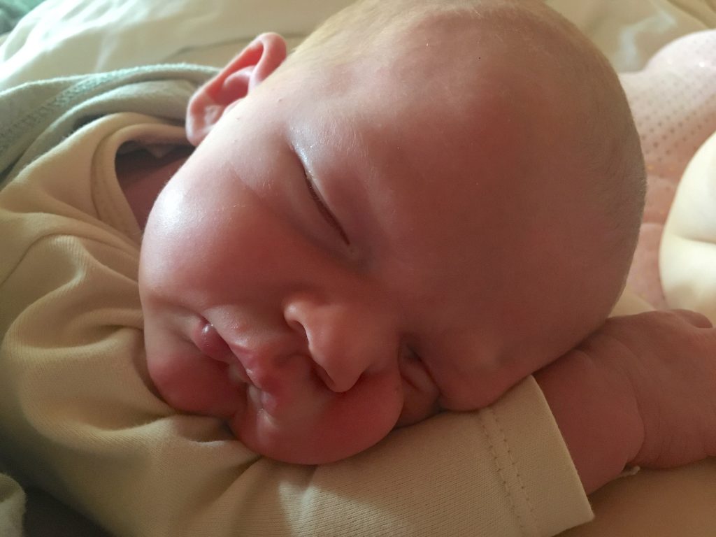 Newborn sleeping on arm