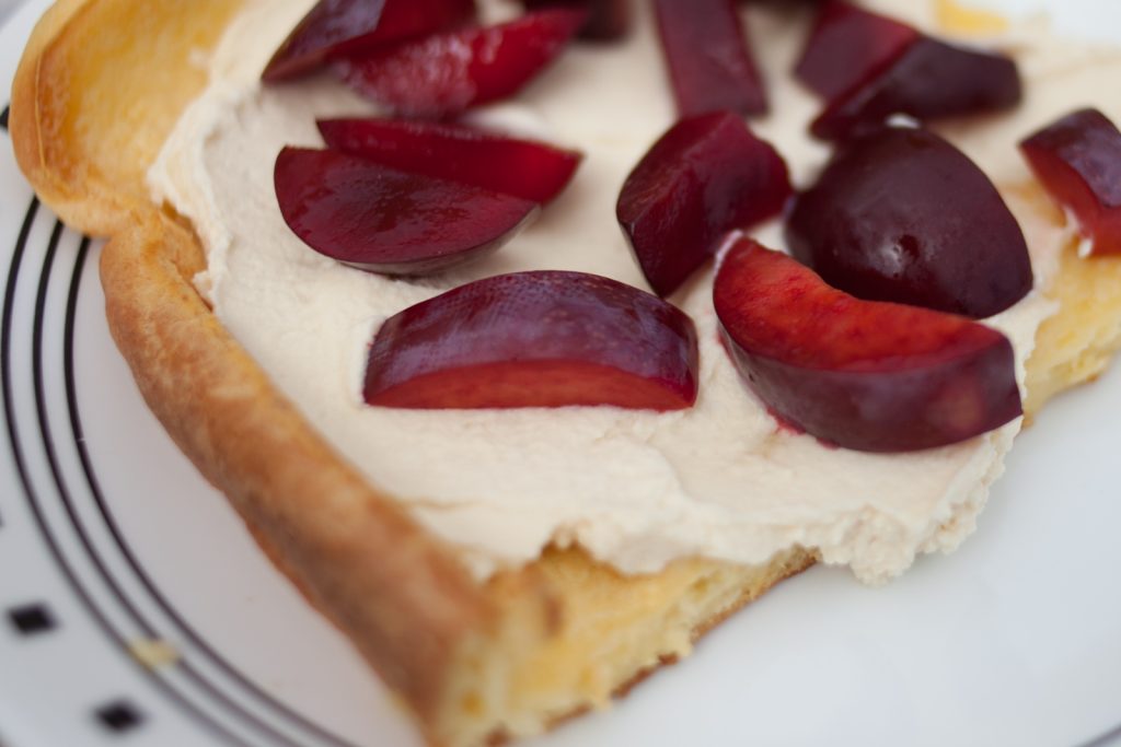 Sheet Pan Swedish Pancake Slice with whip cream and sliced plums