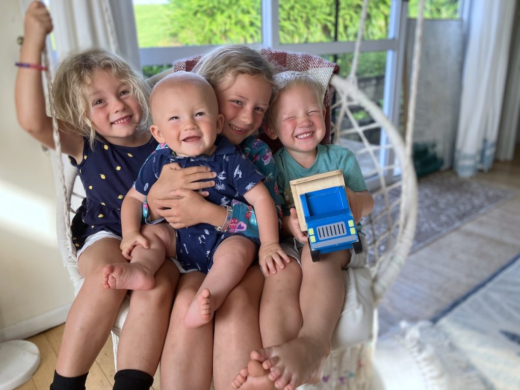 four kids on hammock swing smiling