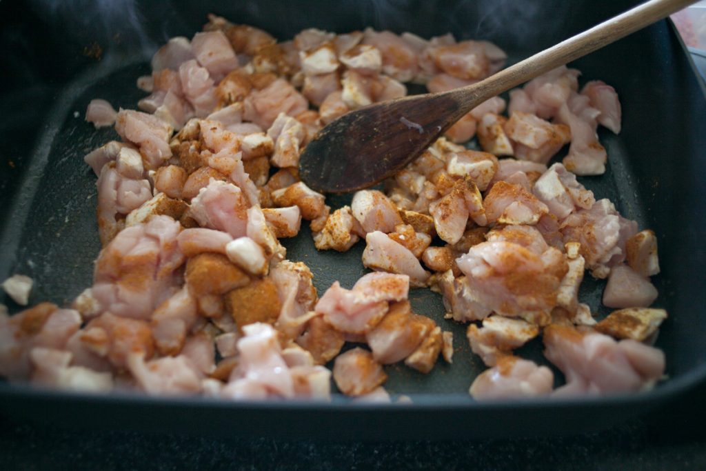 diced chicken breast cooking in electric frying pan