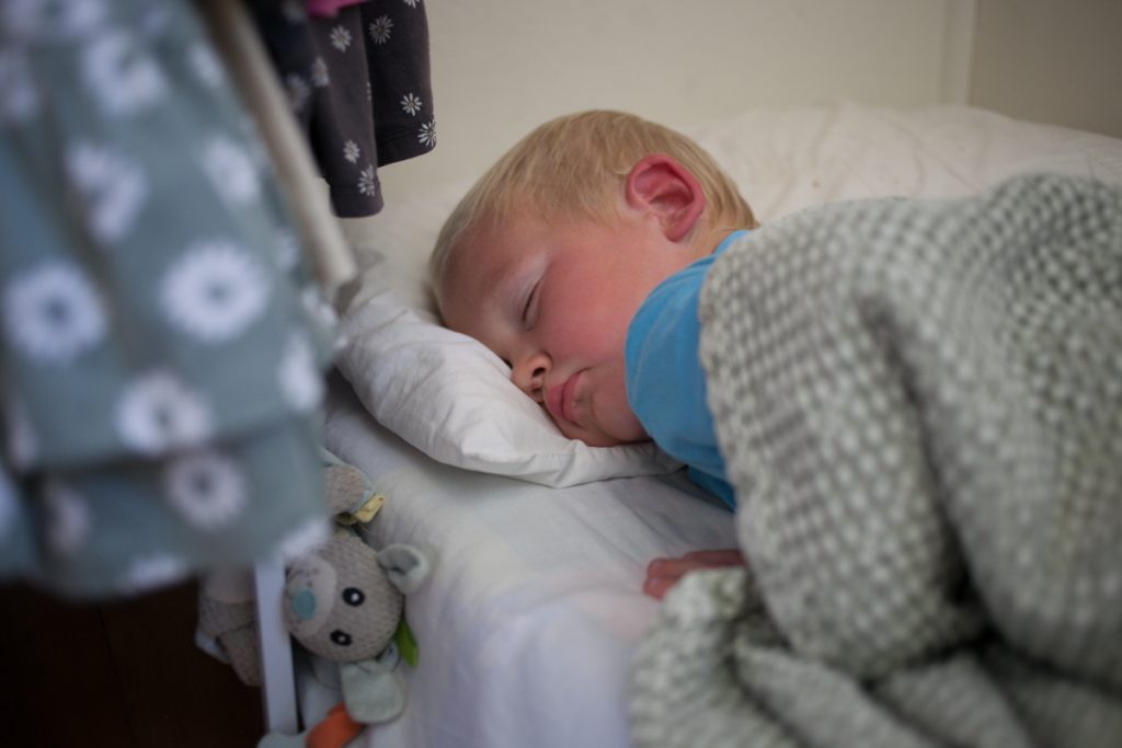 little boy sleeping on bed during quiet rest time