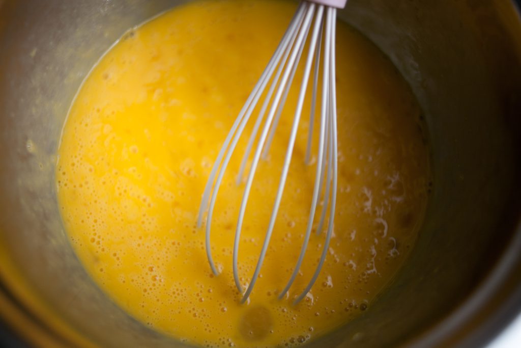 whisked egg mixture in bowl with whisk