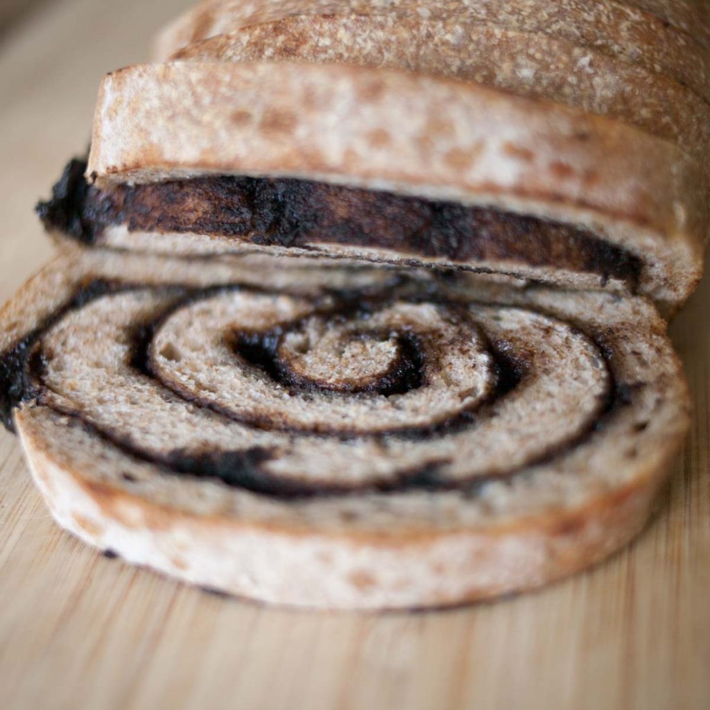 detailed, close up of sourdough chocolate chai swirl bread loaf on cutting board