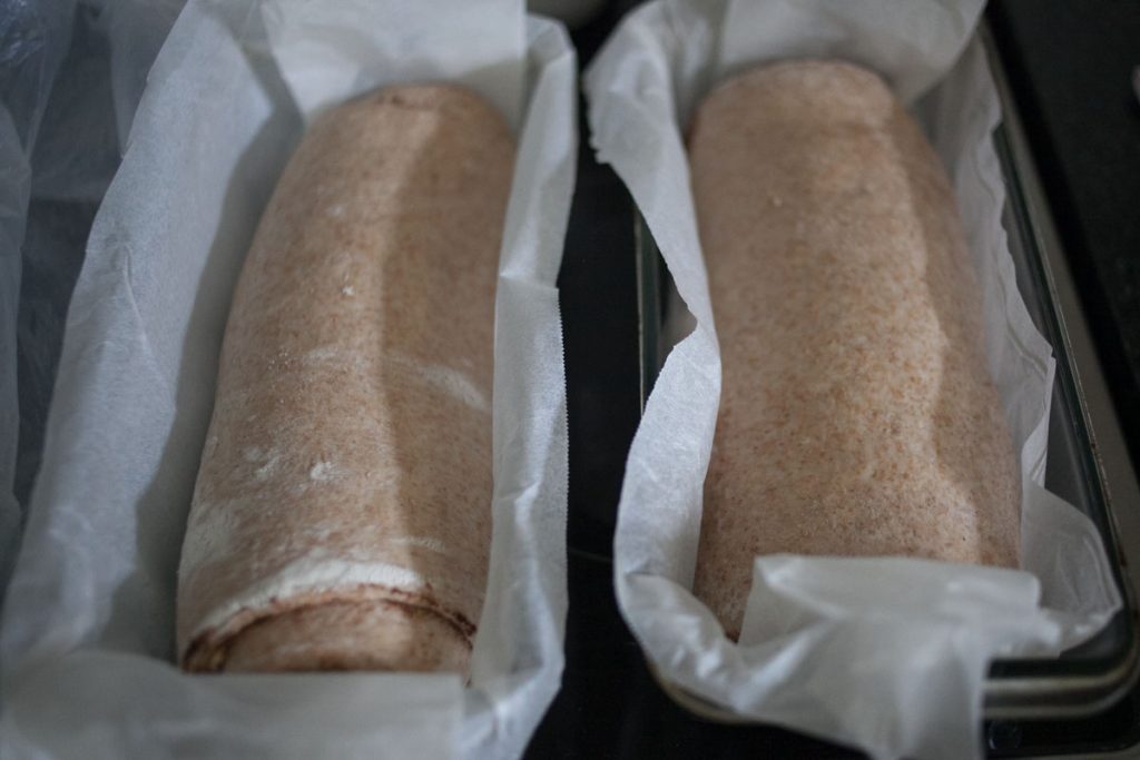 swirl bread in baking pans inside baking paper after final rise