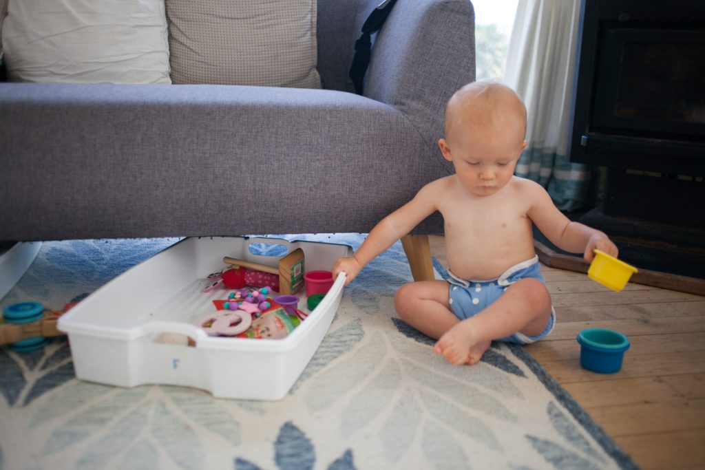 baby sitting on floor playing with toys