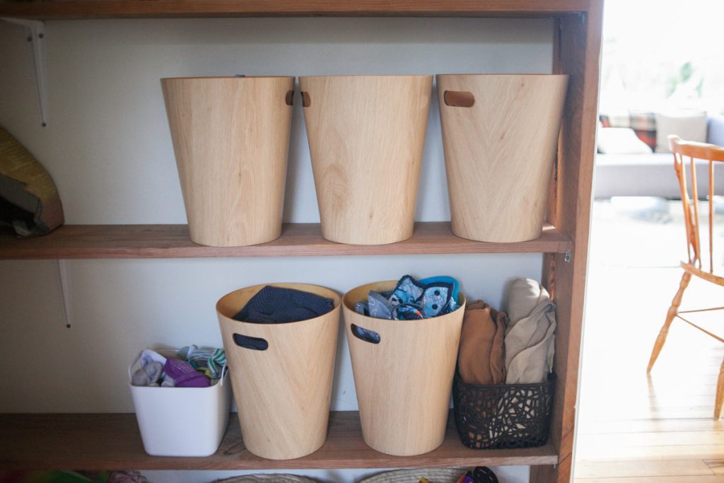 bins for baby clothes on shelf in shared kids room
