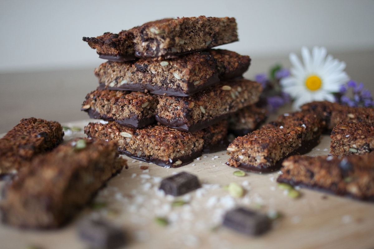 healthy quinoa bars dipped in dark chocolate on a cutting board