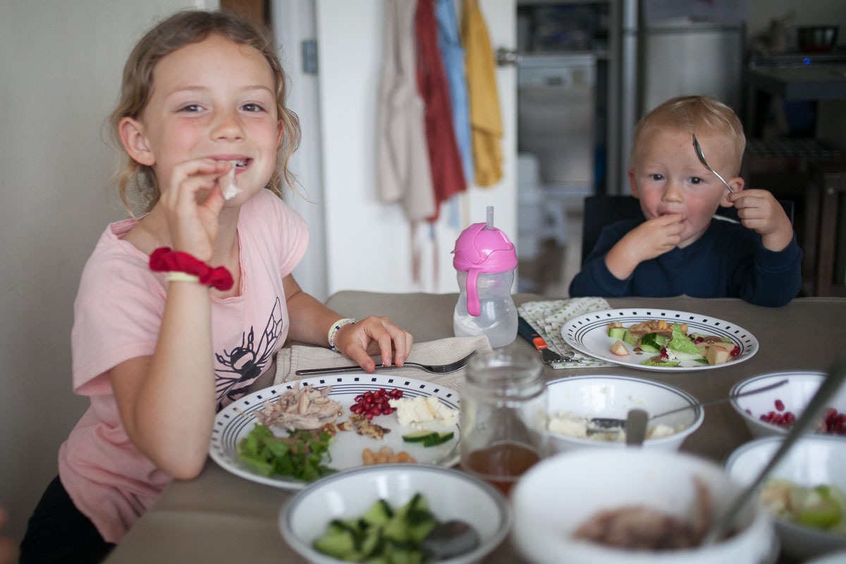 girl and toddler boy eat during simple family dinner routine