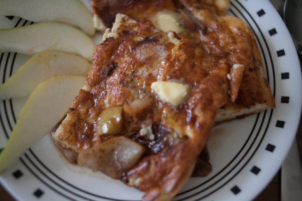 maple syrup and butter melting on spiced pear dutch baby style pancake